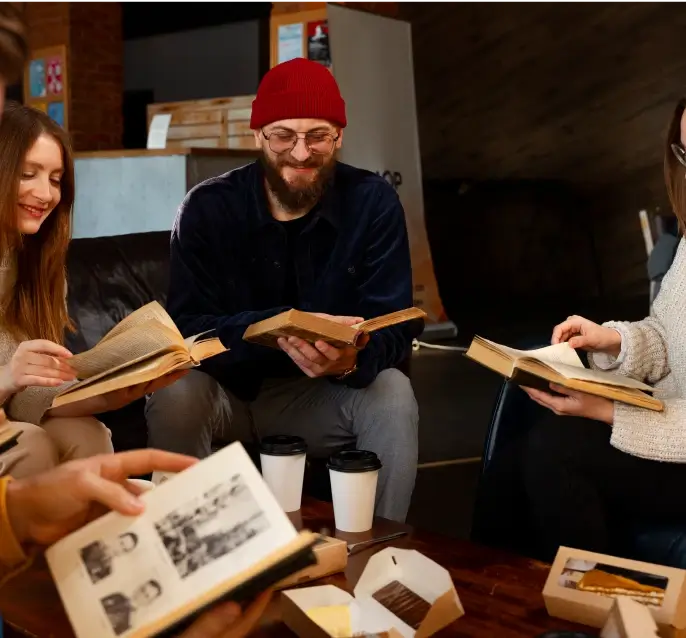 Five people, sitting in a circle, leafing through old books